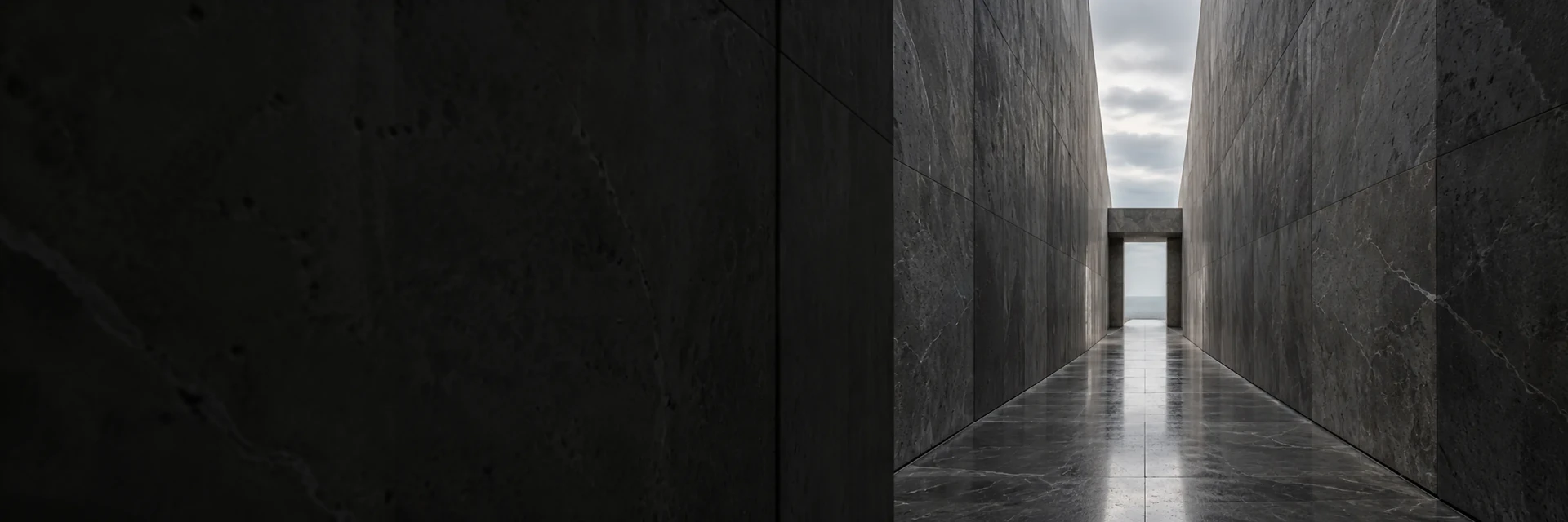 Una sala de reuniones vista a través de vidrio acanalado tras un muro de piedra oscura.